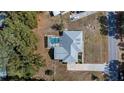 Aerial view of house highlighting screened-in pool, driveway, and landscaping at 10413 Lake Hill Dr, Clermont, FL 34711