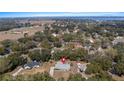 Sprawling neighborhood with mature trees; view of lake in distance, pool and well-maintained landscaping at 10413 Lake Hill Dr, Clermont, FL 34711