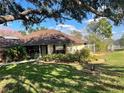 Inviting home exterior with lush landscaping, healthy lawn and mature trees at 11425 Alameda Sandra Dr, Clermont, FL 34711