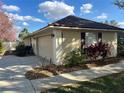 A two-car garage with an extended driveway and manicured landscaping at 11425 Alameda Sandra Dr, Clermont, FL 34711