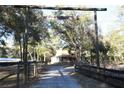 View of home on acreage with a gated entrance and mature shade trees at 1205 Darcy Rd, Lady Lake, FL 32159