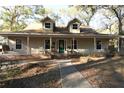 Charming home with dormer windows and a welcoming front porch with swing and chairs at 1205 Darcy Rd, Lady Lake, FL 32159