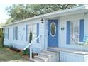 Welcoming front entrance featuring a blue door with an oval window and cozy outdoor seating at 1846 Fruitland Park Blvd, Fruitland Park, FL 34731