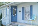 Inviting entryway with blue door, decorative wreath, seating and blue shutters at 1846 Fruitland Park Blvd, Fruitland Park, FL 34731