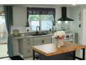 Renovated kitchen featuring gray cabinetry, butcher block island, and modern finishes at 1846 Fruitland Park Blvd, Fruitland Park, FL 34731