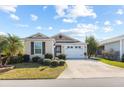 Attractive single-story home boasting a lush lawn, a convenient two-car garage, and lovely landscaping at 1930 Rhett Rd, The Villages, FL 32163