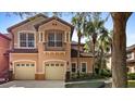 Charming two-story villa showcasing a private balcony, two-car garage, and lush landscaping at 202 Camino Real Blvd # 202, Howey In The Hills, FL 34737