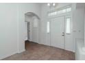 Inviting entryway featuring tile floors, an arched doorway, and a white front door at 2041 Park Forest Blvd, Mount Dora, FL 32757