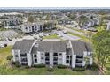 Aerial of condo buildings with lush landscaping, parking, and surrounding neighborhood at 2130 Cascades Blvd # 101, Kissimmee, FL 34741