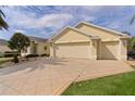 Spacious three-car garage with a paver driveway and well-maintained landscaping at 2190 Derringer Ave, The Villages, FL 32162