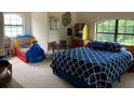 Cozy bedroom featuring a blue and white patterned comforter and a toy bed at 22244 County Road 455, Howey In The Hills, FL 34737