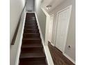 Dark wood staircase with white risers and white trim contrasted by dark wood-look flooring at 2320 Whispering Trails Pl, Winter Haven, FL 33884