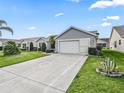 Well maintained home with an expansive driveway and lush landscaping provides excellent curb appeal at 2444 Merida Cir, The Villages, FL 32162