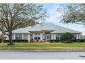 Attractive single-story home with a manicured front lawn, trimmed hedges, bright white trim, and inviting entryway at 24548 Calusa Blvd, Eustis, FL 32736