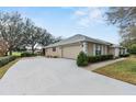 View of the side of the home showing a long driveway to the garage at 24548 Calusa Blvd, Eustis, FL 32736