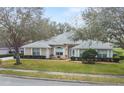 Attractive single-story home with lush front lawn and side-entry garage at 24548 Calusa Blvd, Eustis, FL 32736