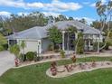 Lovely front exterior of a well-kept home with mature landscaping and a neatly manicured lawn at 27710 Snow Orchid Ct, Leesburg, FL 34748