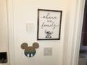 Charming wall decor with Disney-themed accents and modern security system keypad at 294 Captiva Dr, Davenport, FL 33896