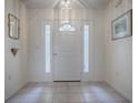 Bright foyer features tiled flooring and a stylish front door with sidelights at 305 Ranchwood Dr, Leesburg, FL 34748