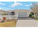 Inviting home exterior with a well-kept lawn, concrete driveway, and attached garage at 308 Emmalee Pl, The Villages, FL 32162