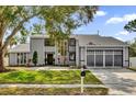 Charming two-story home with gray siding, three-car garage, and lush lawn at 3901 Woodglade Cv, Winter Park, FL 32792