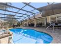 Sparkling in-ground pool in screened lanai with outdoor kitchen, seating and brick paver deck at 39131 Griffin Lndg, Lady Lake, FL 32159