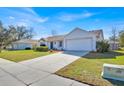 An inviting single-story home with lush front lawn, long driveway and attached two car garage at 406 Bramble Way, Minneola, FL 34715