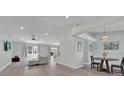 Spacious open-concept living room with a ceiling fan, light gray walls and recessed lighting at 406 Bramble Way, Minneola, FL 34715