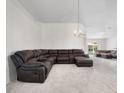 Spacious living room featuring neutral carpet, a modern chandelier, and a comfortable large couch at 464 Dominish Estates Dr, Apopka, FL 32712