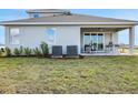 Exterior view of backyard featuring a covered patio with furniture, lawn and landscaping at 5306 Marshelder St, Apopka, FL 32712