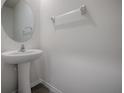 Powder room with pedestal sink, round mirror, and a towel bar for convenience at 5391 Dragonfly Dr, Wildwood, FL 34785