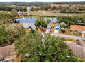 An aerial view of a home with a pond nearby and a clear view of neighborhood at 5428 Tangelo St, Leesburg, FL 34748