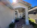 Inviting front entrance with a tiled walkway, covered porch, and glass front door at 8004 Saint Andrews Way, Mount Dora, FL 32757