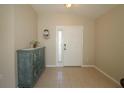 Inviting entryway featuring neutral tile flooring, a decorative cabinet, and a bright front door with sidelight at 8660 Se 132Nd Ln, Summerfield, FL 34491