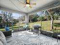 Covered porch with a grill, hanging chair, and views of the backyard at 887 Daisy Hill Ct, Apopka, FL 32712