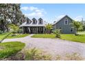 Charming home featuring a gravel driveway and a well-manicured front lawn with trees at 9905 Skylark Ln, Groveland, FL 34736