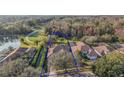 Aerial view of the property showcasing the tile roof, screened pool area, and proximity to the golf course and pond at 9930 Santa Barbara Ct, Howey In The Hills, FL 34737