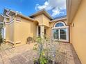 Inviting home exterior featuring an arched entryway and meticulously maintained landscaping at 100 Grand Reserve Dr, Davenport, FL 33837