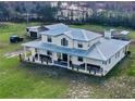 Stunning two-story home featuring a metal roof and a charming wraparound porch at 10909 Mattioda Rd, Groveland, FL 34736