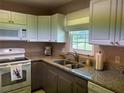 Well-lit kitchen featuring granite countertops, stainless steel appliances, and white and brown cabinetry at 1152 Villa Ln # 104, Apopka, FL 32712