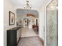 Charming foyer boasting tile floors, decorative rug, and an elegant chandelier at 12335 Se 176Th Loop, Summerfield, FL 34491