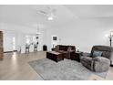 Open-concept living room with tile floors, ceiling fan, and comfortable seating arrangement at 1392 Kenneth St, The Villages, FL 34762