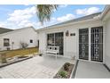 Inviting front entrance with secure steel doors, a seating area, and well-maintained landscaping at 1508 Dellano Way, The Villages, FL 32159