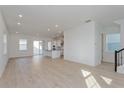 Open-concept living room with light wood floors and ample natural light at 16465 Hamlin View St, Winter Garden, FL 34787