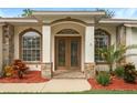 Inviting front entrance featuring a decorative double door, stone accents, and mature landscaping at 16627 Rockwell Heights Ln, Clermont, FL 34711