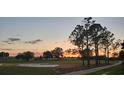 Scenic view of the golf course at sunset with mature trees and manicured greens at 1840 Madero Dr, The Villages, FL 32159