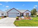 Charming single-story home with a well-manicured lawn, stone accents, and an attached two-car garage at 1914 Antonia Pl, The Villages, FL 32159