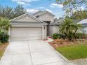 A well-maintained single-Gathering home with a two-car garage and green lawn, showcasing its tidy curb appeal at 235 Pima Trl, Groveland, FL 34736