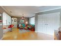 Bright living room featuring hardwood floors, large double doors, and stylish mid-century modern furnishings at 2422 Topping Pl, Eustis, FL 32726