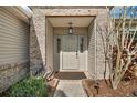 Inviting front porch featuring brick accents, a hanging lantern, and a well-maintained entrance at 25073 Riverwalk Dr, Leesburg, FL 34748